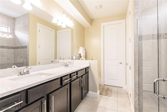 bathroom with double vanity, a stall shower, a sink, and tile patterned floors