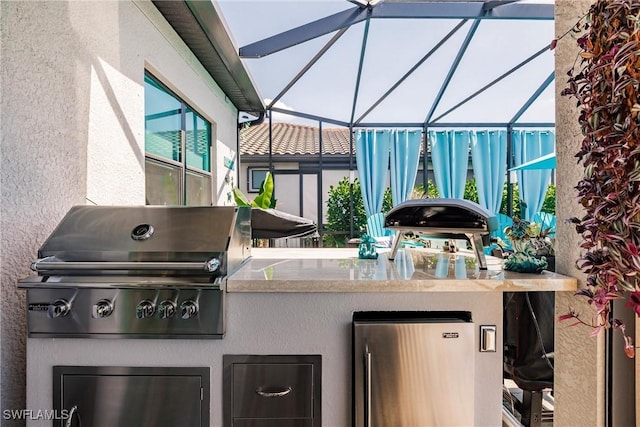 view of patio / terrace with glass enclosure, grilling area, and an outdoor kitchen