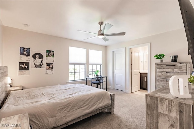 bedroom featuring ceiling fan, connected bathroom, and light colored carpet