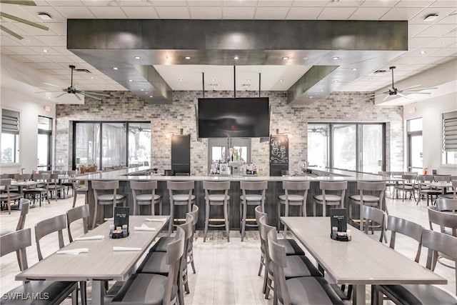 dining space featuring a paneled ceiling, light wood-style floors, and ceiling fan