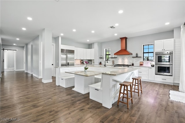 1474 Saint Clair Shores Rd, Naples, FL 34104 - kitchen featuring appliances with stainless steel finishes, a spacious island, wall chimney exhaust hood, recessed lighting, and decorative backsplash
