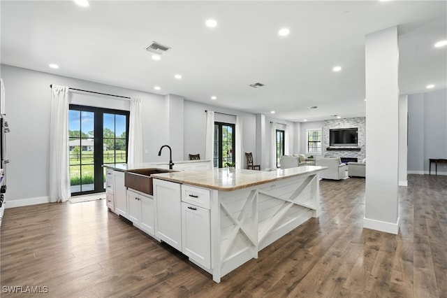 1474 Saint Clair Shores Rd, Naples, FL 34104 - kitchen with a large island with sink, healthy amount of natural light, white cabinetry, recessed lighting, and dark wood-style floors