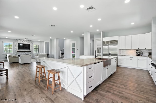 1474 Saint Clair Shores Rd, Naples, FL 34104 - kitchen with a large island, light stone countertops, dark wood-type flooring, stainless steel built in refrigerator, and backsplash