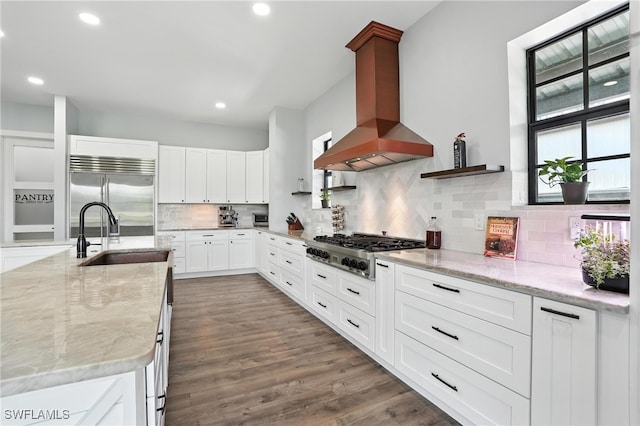 1474 Saint Clair Shores Rd, Naples, FL 34104 - kitchen with appliances with stainless steel finishes, wall chimney exhaust hood, light stone counters, backsplash, and white cabinetry