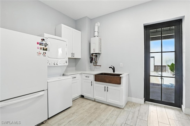 1474 Saint Clair Shores Rd, Naples, FL 34104 - kitchen with freestanding refrigerator, stacked washing machine and dryer, light countertops, white cabinets, and water heater