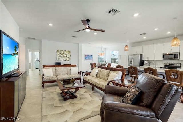 living area featuring light tile patterned floors, a ceiling fan, visible vents, and recessed lighting