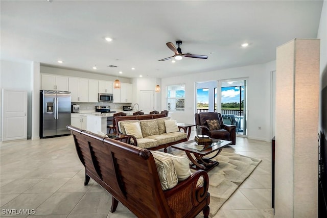 living room featuring light tile patterned floors, baseboards, a ceiling fan, and recessed lighting