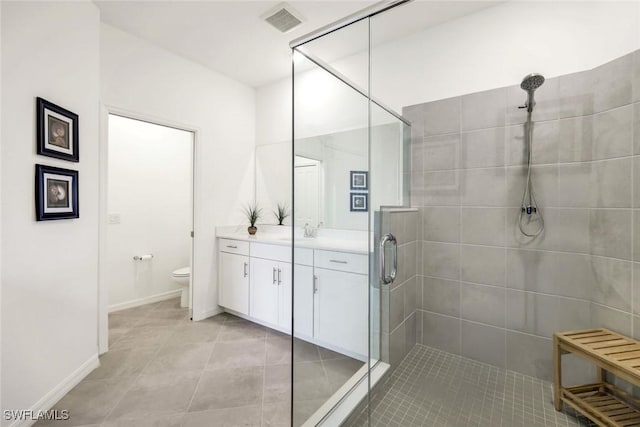 bathroom with toilet, visible vents, vanity, a shower stall, and tile patterned floors