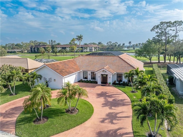 view of front of home with a garage, a tiled roof, decorative driveway, and a front yard