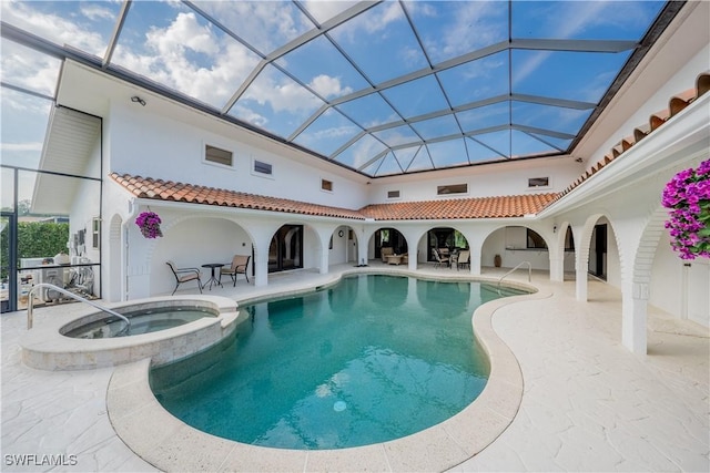 view of swimming pool with a lanai, a patio area, and a pool with connected hot tub