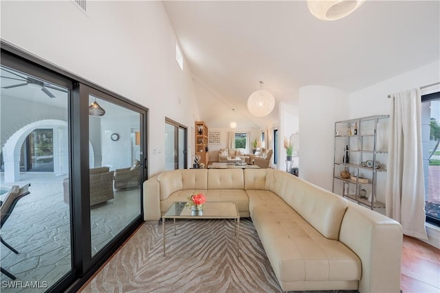 living room with visible vents, a healthy amount of sunlight, and high vaulted ceiling