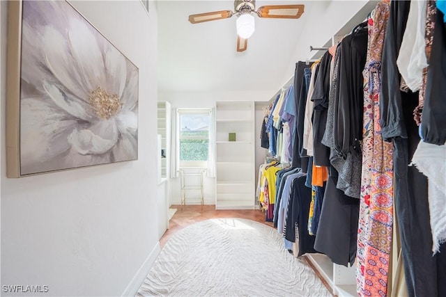 walk in closet featuring a ceiling fan