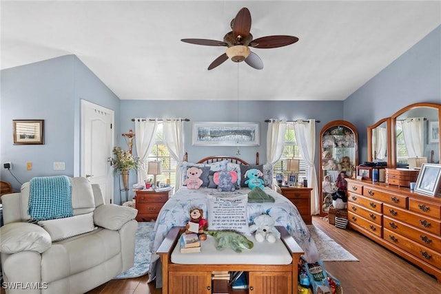 bedroom featuring ceiling fan, wood finished floors, and vaulted ceiling