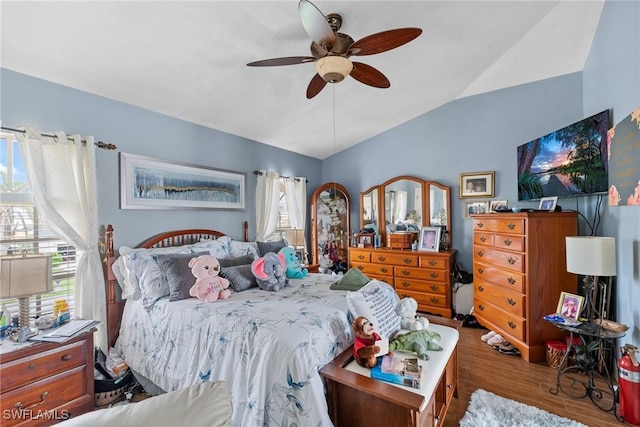 bedroom featuring ceiling fan, wood finished floors, and vaulted ceiling