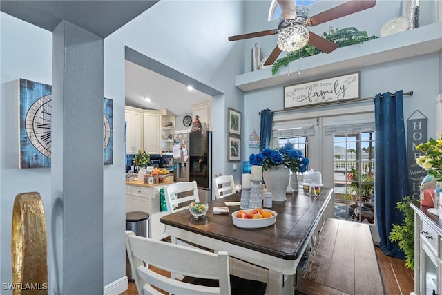 dining area with french doors, a high ceiling, and wood finished floors