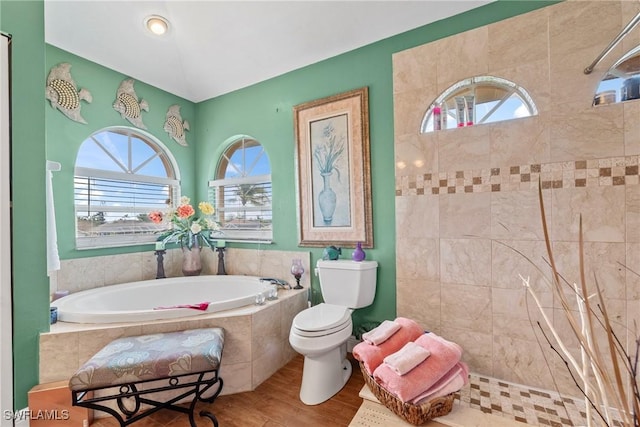 bathroom with a garden tub, wood finished floors, toilet, and a tile shower