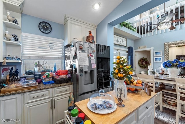 kitchen with open shelves, white cabinetry, stainless steel refrigerator with ice dispenser, and a ceiling fan