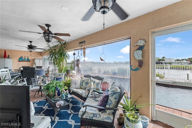 sunroom / solarium featuring a ceiling fan