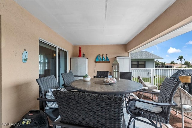 balcony featuring outdoor dining space and a sunroom