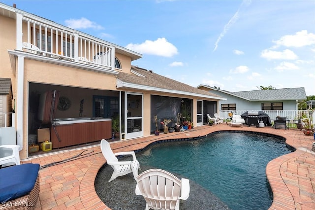 view of swimming pool featuring a patio, grilling area, fence, and a hot tub