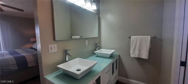 bathroom featuring ceiling fan, double vanity, a sink, and connected bathroom