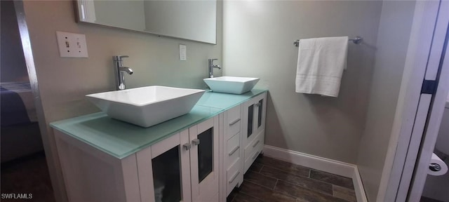 full bathroom featuring double vanity, a sink, and baseboards