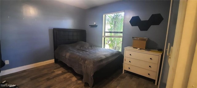 bedroom with dark wood-type flooring and baseboards