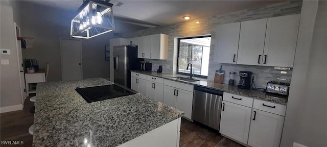 kitchen with a center island, dark wood-style flooring, stainless steel appliances, tasteful backsplash, and a sink