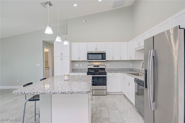 kitchen featuring visible vents, a kitchen island, high vaulted ceiling, appliances with stainless steel finishes, and white cabinetry