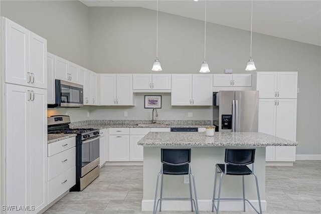 kitchen featuring a breakfast bar area, a sink, white cabinets, appliances with stainless steel finishes, and a center island