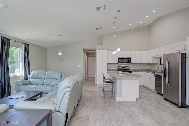 kitchen with open floor plan, stainless steel appliances, visible vents, and a sink