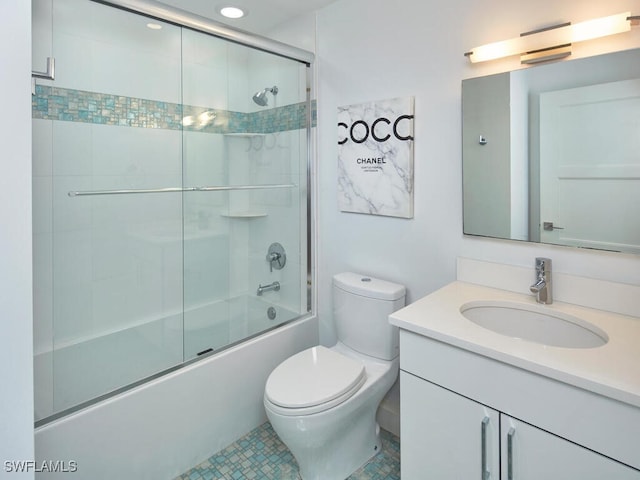 full bathroom featuring combined bath / shower with glass door, vanity, and toilet