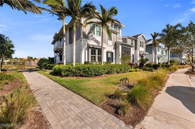 view of front of property with a front yard, a residential view, and stucco siding