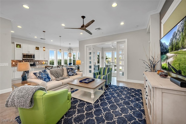 living room with recessed lighting, visible vents, baseboards, a ceiling fan, and ornamental molding