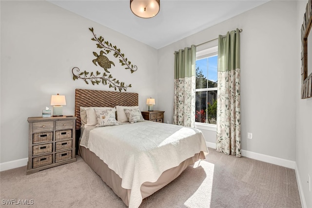 bedroom with light colored carpet and baseboards