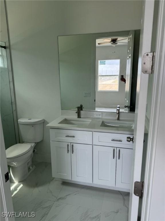 full bathroom featuring double vanity, marble finish floor, toilet, and a sink