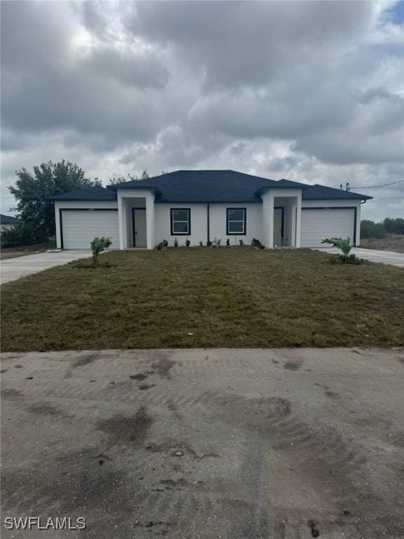 view of front of property featuring stucco siding, a front lawn, concrete driveway, and a garage