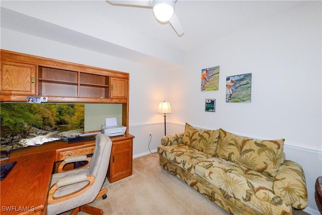 home office with light carpet, ceiling fan, and built in desk