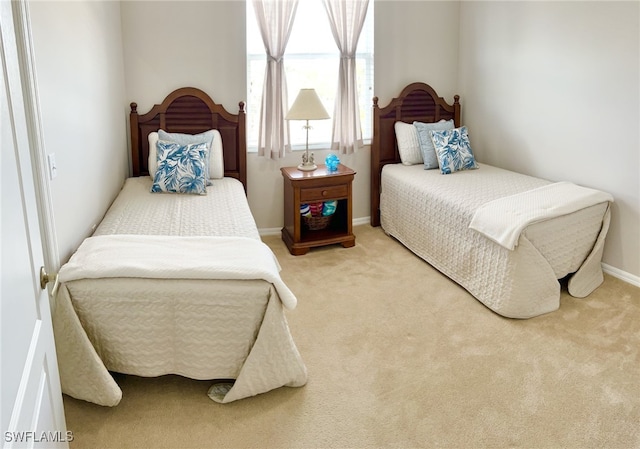 bedroom featuring baseboards and light colored carpet