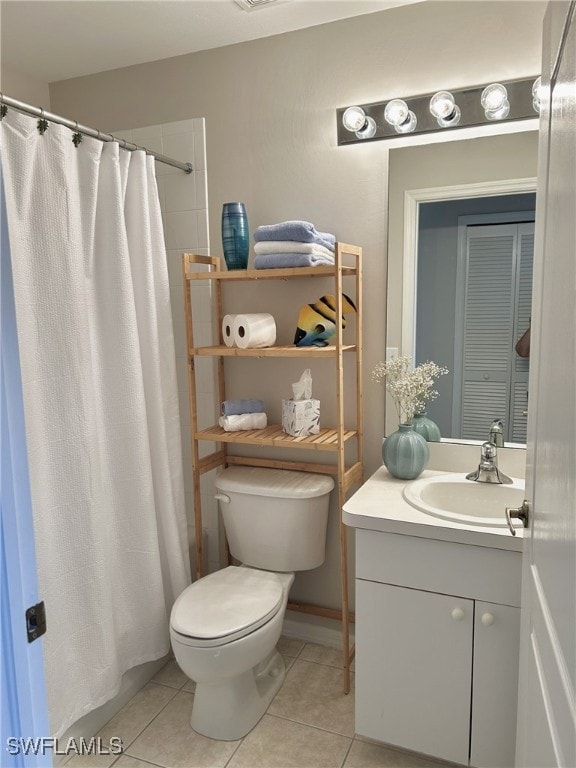 bathroom with toilet, curtained shower, vanity, and tile patterned floors