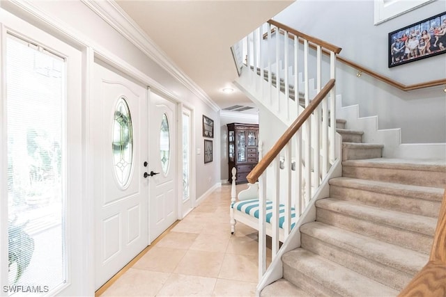 entrance foyer with light tile patterned floors, stairway, baseboards, and crown molding