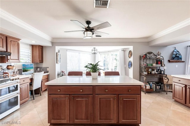 kitchen featuring crown molding, visible vents, range with two ovens, and light countertops