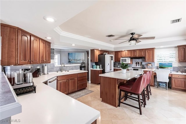 kitchen with white appliances, tasteful backsplash, a breakfast bar, and a sink