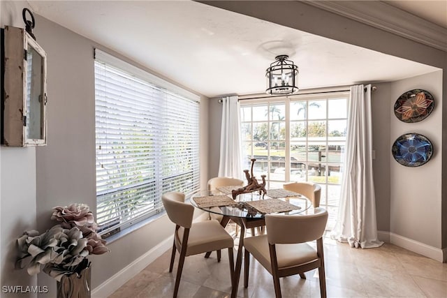 dining area with a chandelier, light tile patterned floors, and baseboards