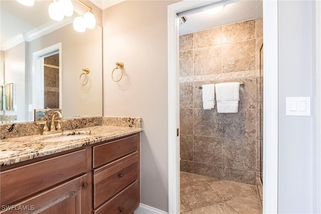 full bath featuring tiled shower, vanity, and crown molding