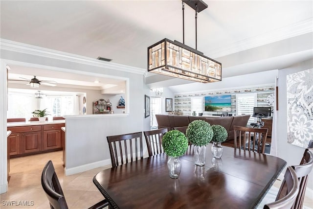 dining room with light tile patterned floors, baseboards, visible vents, crown molding, and ceiling fan with notable chandelier