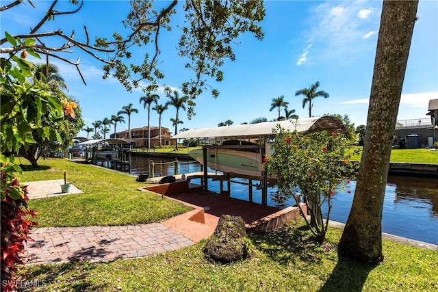 view of dock with a lawn, a water view, and boat lift