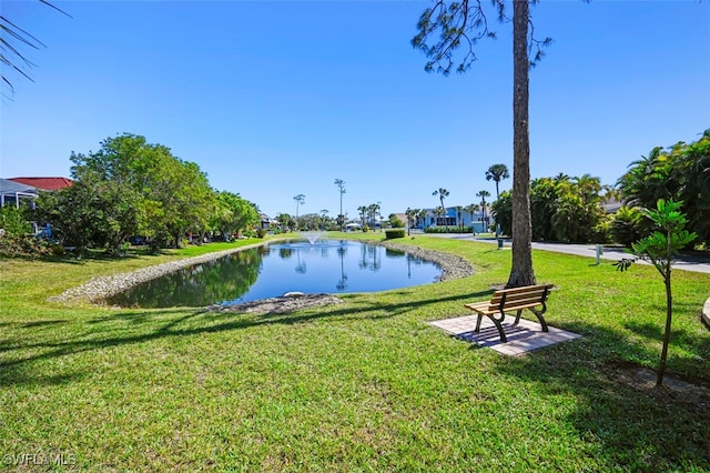 surrounding community featuring a water view and a lawn