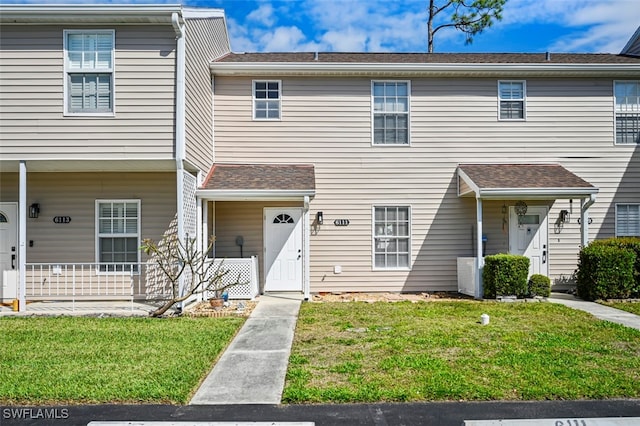 townhome / multi-family property with a porch and a front yard