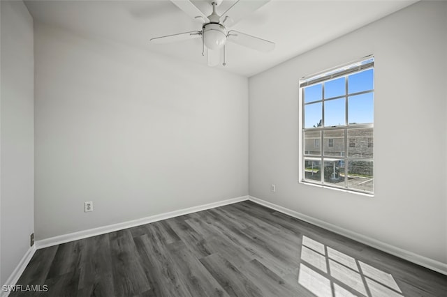 unfurnished room with ceiling fan, baseboards, and dark wood-type flooring